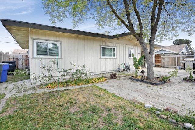 1016 N White St, Hanford, CA 93230 - back of house with board and batten siding, a patio, and fence
