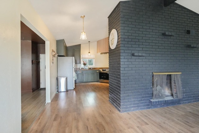 1016 N White St, Hanford, CA 93230 - kitchen with vaulted ceiling, freestanding refrigerator, stainless steel stove, and light wood-style flooring