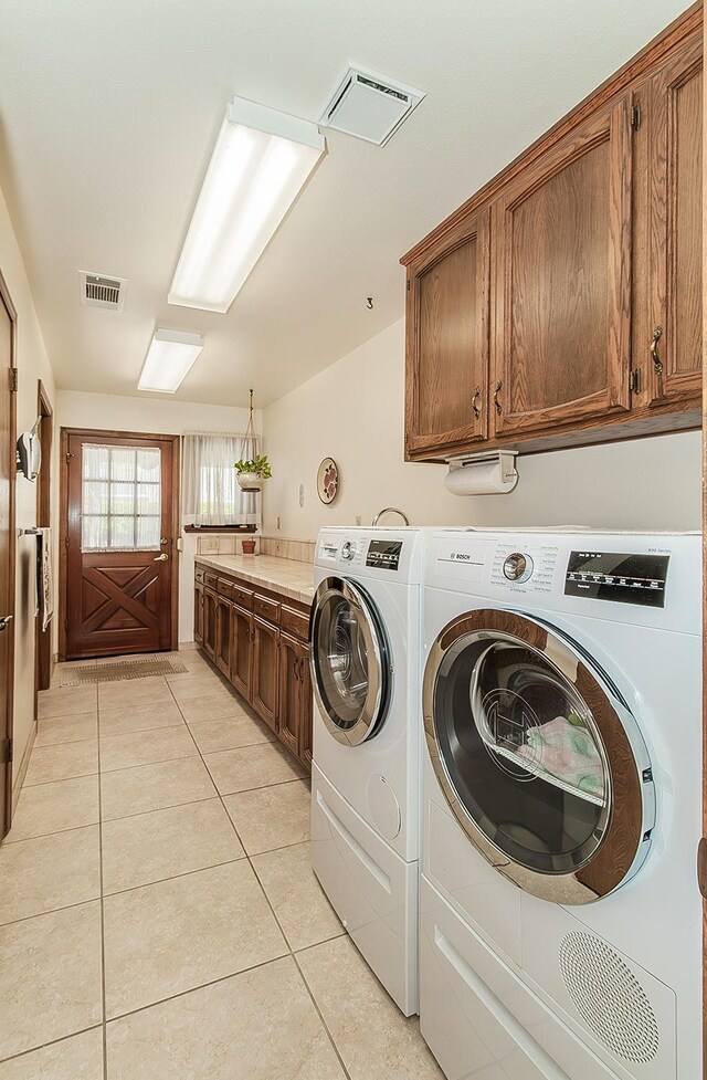 7355 N Pacific Ave, Fresno, CA 93711 - washroom with visible vents, washer and dryer, light tile patterned floors, and cabinet space