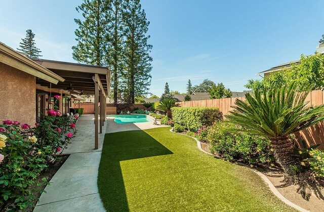 7355 N Pacific Ave, Fresno, CA 93711 - view of yard featuring ceiling fan, a fenced backyard, a fenced in pool, and a patio