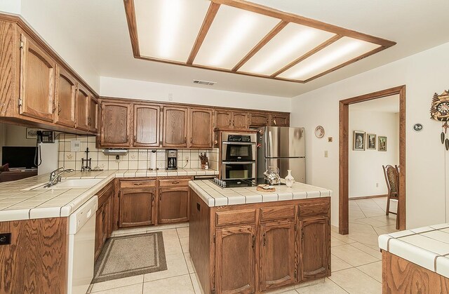 7355 N Pacific Ave, Fresno, CA 93711 - kitchen featuring stainless steel appliances, visible vents, backsplash, tile counters, and light tile patterned floors