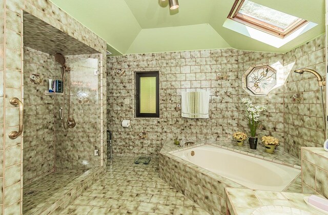 7355 N Pacific Ave, Fresno, CA 93711 - full bathroom with a garden tub, vaulted ceiling with skylight, tile walls, and a stall shower
