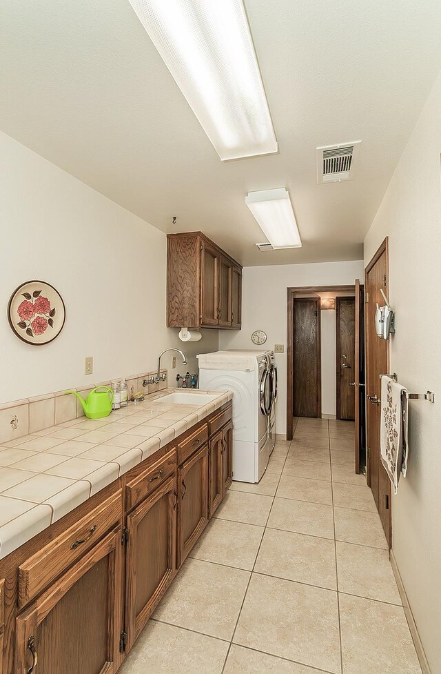 7355 N Pacific Ave, Fresno, CA 93711 - laundry area with a sink, light tile patterned floors, cabinet space, visible vents, and independent washer and dryer