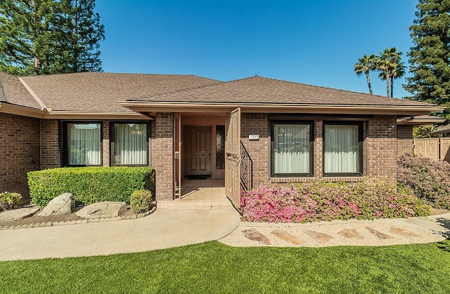 7355 N Pacific Ave, Fresno, CA 93711 - view of exterior entry with brick siding and a shingled roof