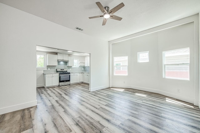 unfurnished living room featuring baseboards, a ceiling fan, visible vents, and light wood-type flooring