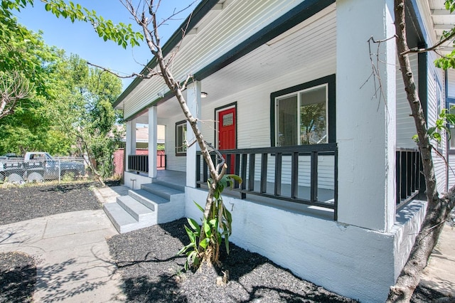 view of front of house featuring a porch and fence