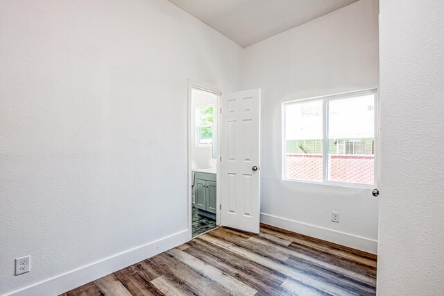 unfurnished room featuring baseboards and wood finished floors