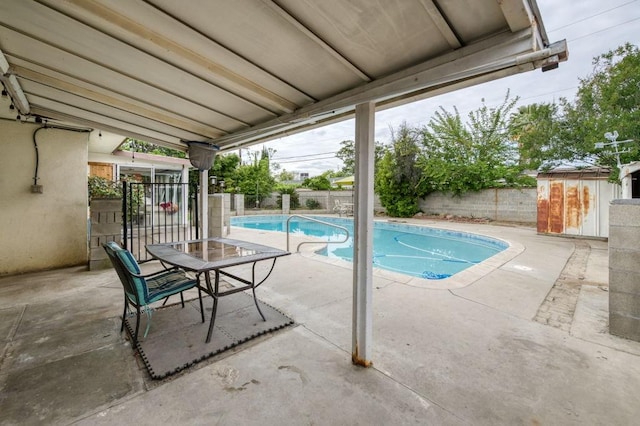 view of swimming pool with a patio area, a shed, a fenced backyard, an outdoor structure, and a fenced in pool