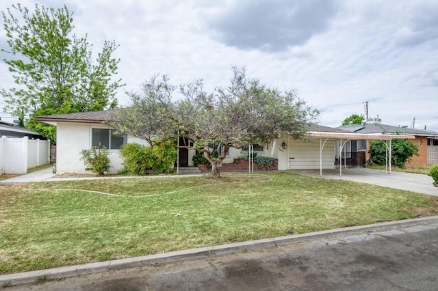 view of front of property featuring stucco siding, a front lawn, concrete driveway, and fence