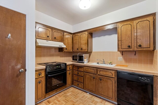 4311 N Emerson Ave, Fresno, CA 93705 - kitchen featuring a sink, decorative backsplash, brown cabinets, under cabinet range hood, and black appliances