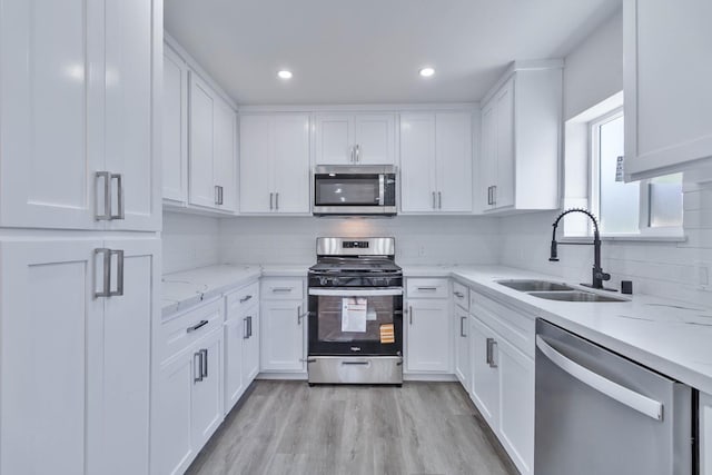227 E Pine Ave, Fresno, CA 93728 - kitchen featuring stainless steel appliances, a sink, white cabinetry, backsplash, and light stone countertops