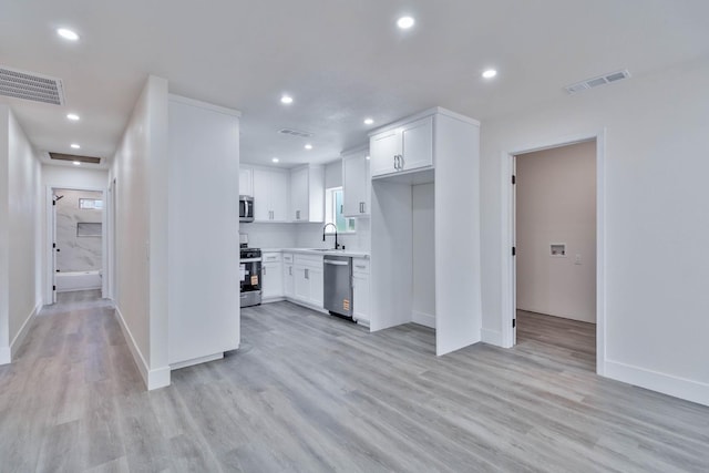 227 E Pine Ave, Fresno, CA 93728 - kitchen featuring stainless steel appliances, white cabinets, light wood-style flooring, light countertops, and baseboards