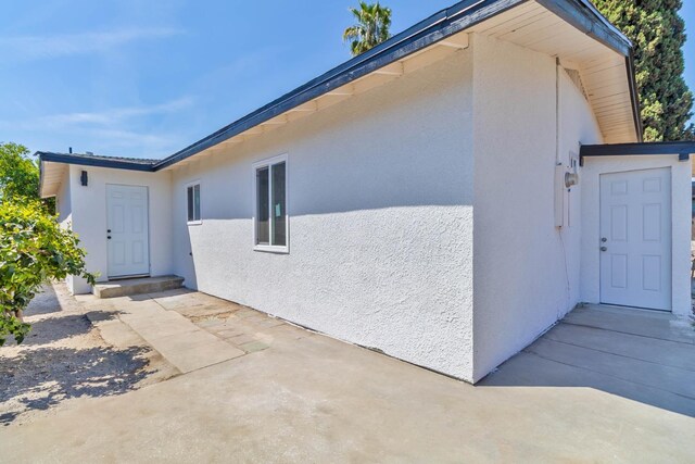 227 E Pine Ave, Fresno, CA 93728 - view of property exterior with stucco siding and a patio