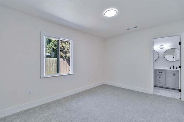 227 E Pine Ave, Fresno, CA 93728 - unfurnished bedroom featuring light colored carpet, baseboards, a sink, and ensuite bathroom