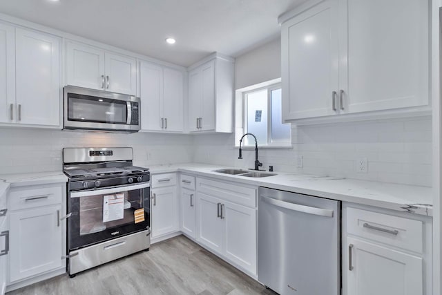 227 E Pine Ave, Fresno, CA 93728 - kitchen featuring stainless steel appliances, a sink, white cabinets, backsplash, and light stone countertops