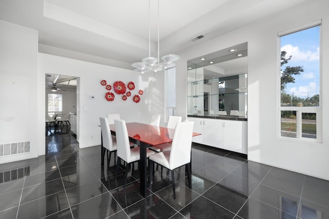 dining space with a chandelier, a tray ceiling, visible vents, and recessed lighting