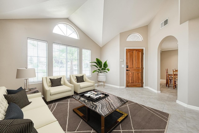 5711 W Fallon Ave, Fresno, CA 93722 - living area featuring arched walkways, light tile patterned flooring, baseboards, visible vents, and high vaulted ceiling