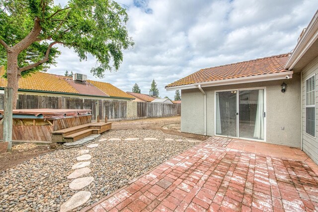5711 W Fallon Ave, Fresno, CA 93722 - view of patio featuring a fenced backyard, a hot tub, and central AC