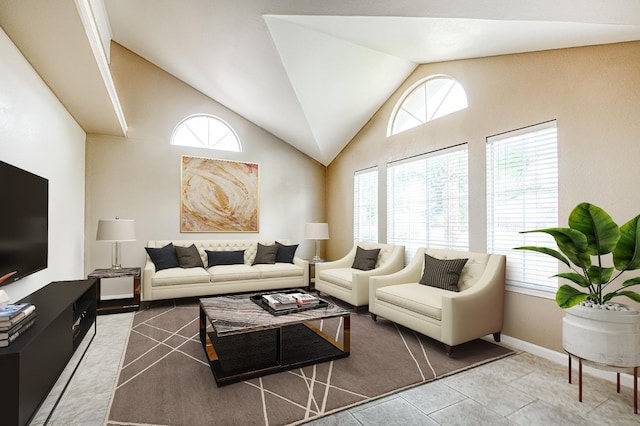5711 W Fallon Ave, Fresno, CA 93722 - living room featuring vaulted ceiling, a healthy amount of sunlight, tile patterned flooring, and baseboards