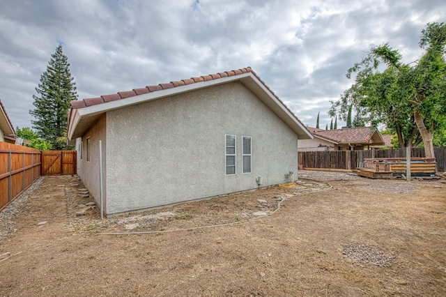 5711 W Fallon Ave, Fresno, CA 93722 - back of house featuring a fenced backyard, a tiled roof, and stucco siding
