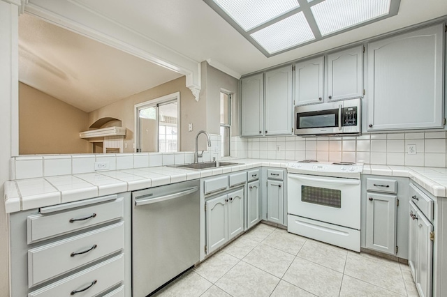 5711 W Fallon Ave, Fresno, CA 93722 - kitchen with stainless steel appliances, a sink, backsplash, and light tile patterned floors