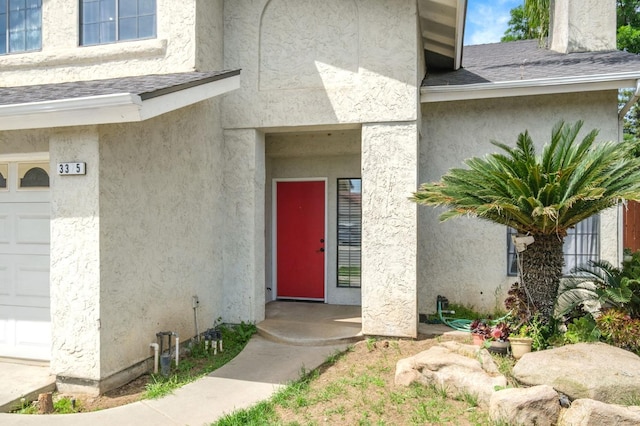 3375 N Berlin Ave, Fresno, CA 93722 - view of exterior entry with stucco siding, roof with shingles, and a garage