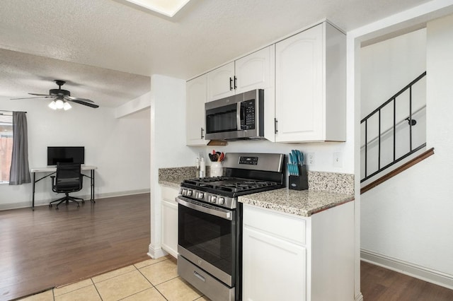 3375 N Berlin Ave, Fresno, CA 93722 - kitchen with white cabinets, a ceiling fan, light stone countertops, a textured ceiling, and appliances with stainless steel finishes