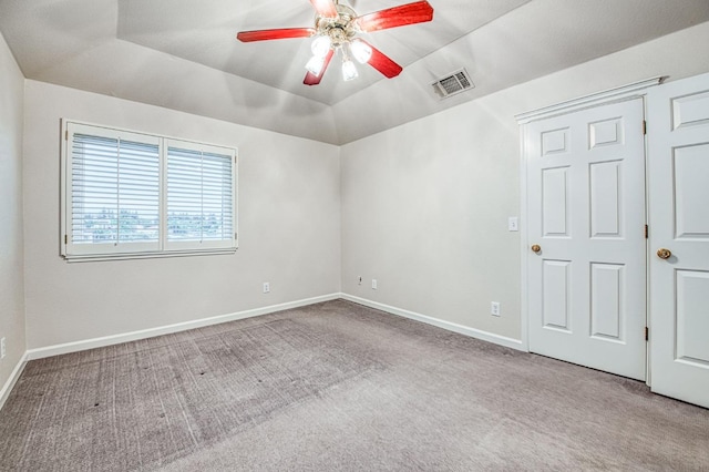 spare room featuring a ceiling fan, visible vents, and carpet