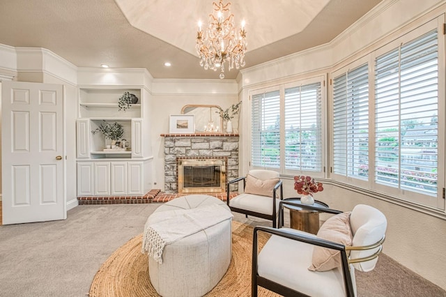 living area with carpet flooring, a fireplace, a chandelier, and ornamental molding