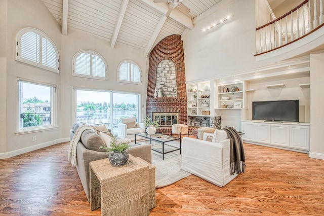 living room featuring high vaulted ceiling, wood ceiling, a brick fireplace, and light wood-style floors