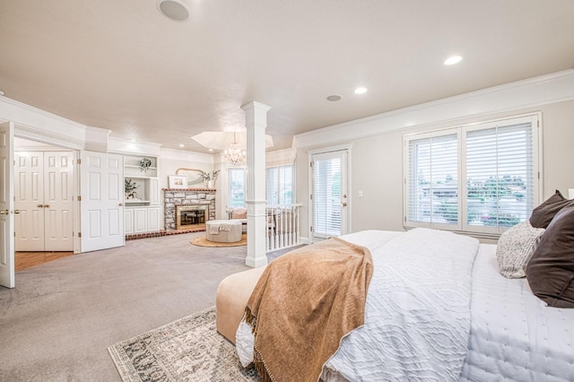 bedroom featuring crown molding, a stone fireplace, decorative columns, access to exterior, and recessed lighting