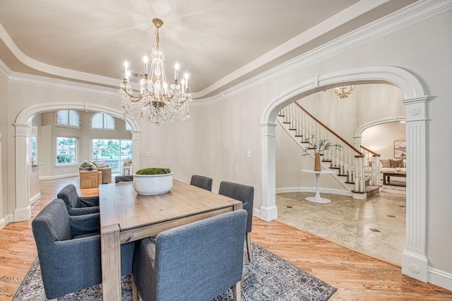 dining space with stairway, arched walkways, crown molding, and a chandelier