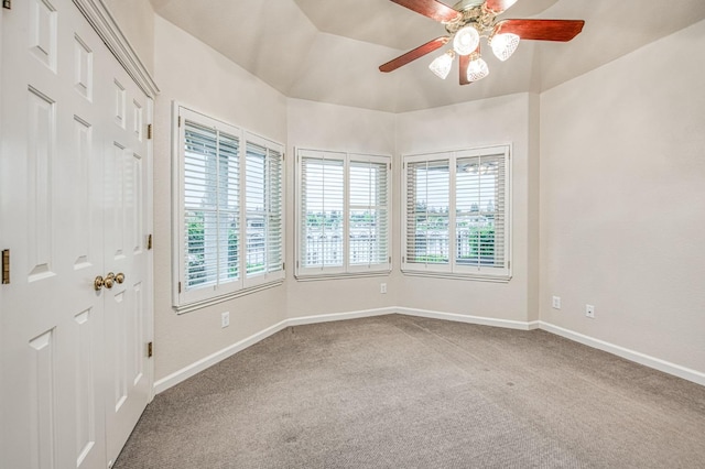 carpeted empty room featuring baseboards and a ceiling fan
