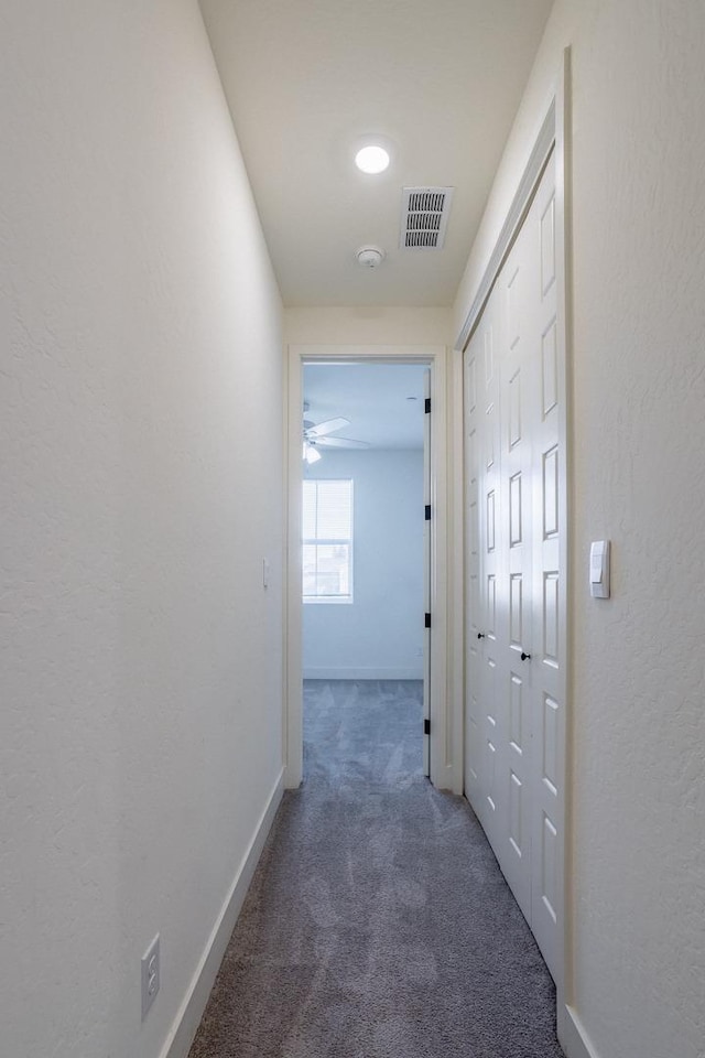 hall featuring visible vents, carpet flooring, and baseboards