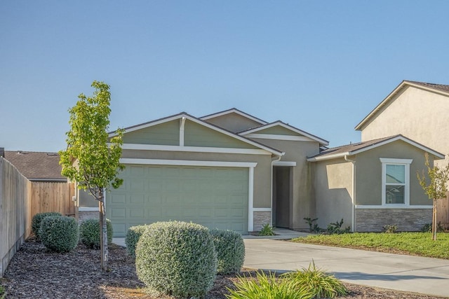 ranch-style home with a garage, driveway, stone siding, and fence
