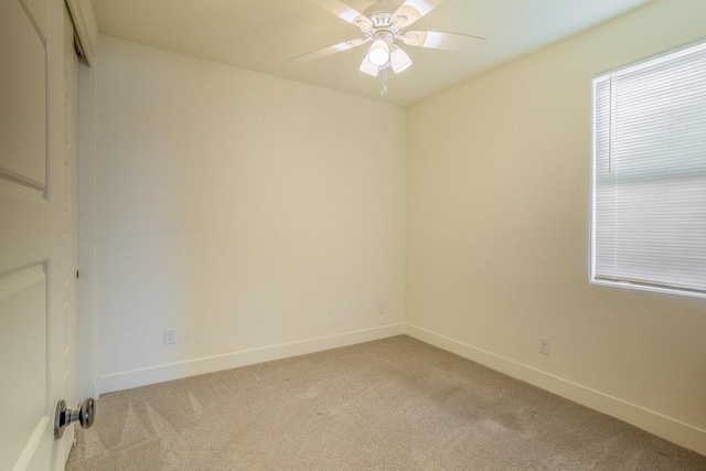 unfurnished room featuring baseboards, light colored carpet, and ceiling fan