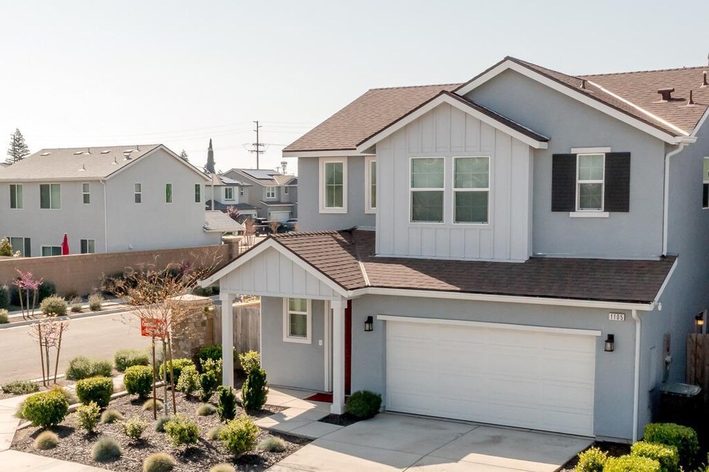 1105 W Sedona Ave, Visalia, CA 93291 - traditional home featuring an attached garage, fence, board and batten siding, and driveway