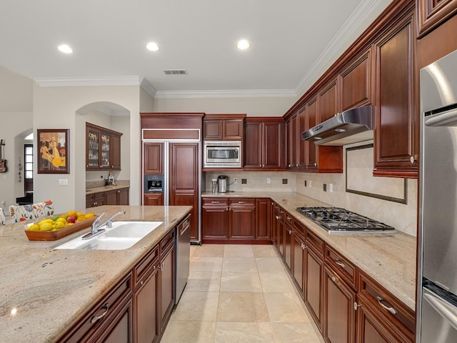 10640 N Old Course Dr, Fresno, CA 93730 - kitchen featuring arched walkways, a sink, appliances with stainless steel finishes, under cabinet range hood, and ornamental molding