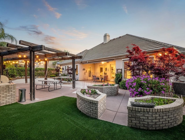 10640 N Old Course Dr, Fresno, CA 93730 - back of property at dusk with a chimney, a pergola, a tiled roof, a yard, and a patio