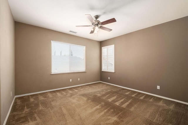 unfurnished room with visible vents, carpet floors, ceiling fan, and a healthy amount of sunlight