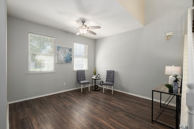 living area with baseboards, a ceiling fan, and wood finished floors