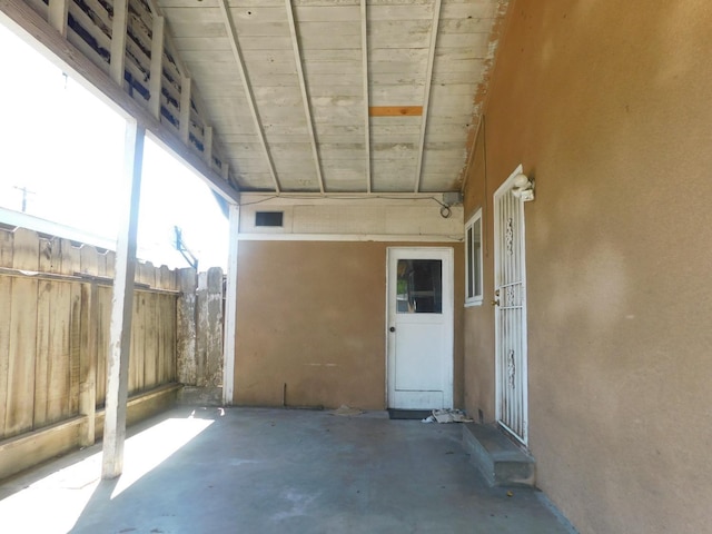 property entrance featuring a patio, stucco siding, and fence