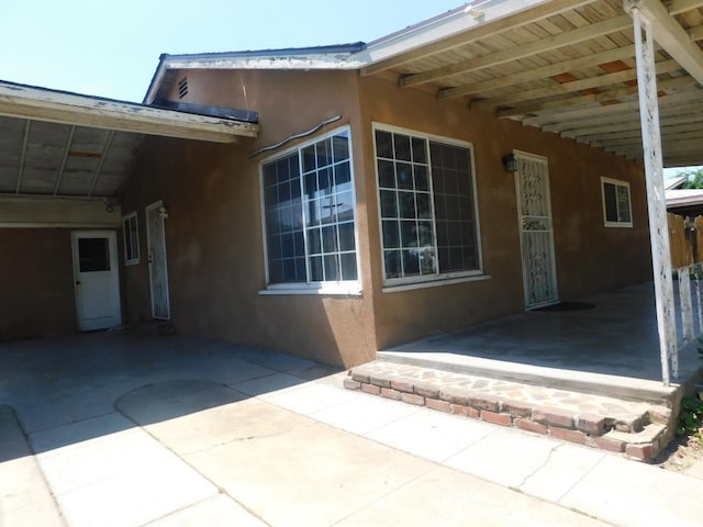 view of property exterior featuring an attached carport and stucco siding