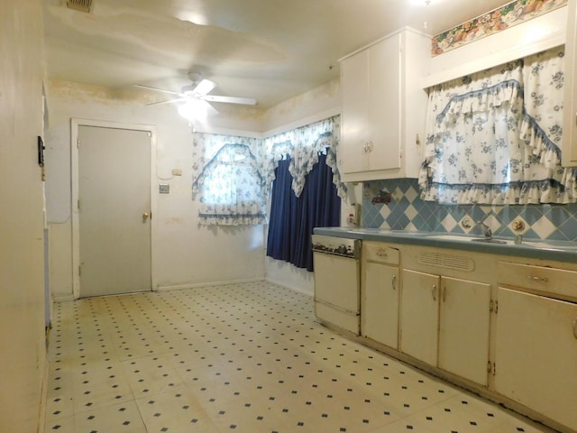 kitchen with light floors, visible vents, dishwashing machine, a ceiling fan, and decorative backsplash