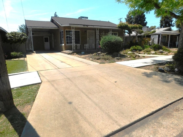 single story home featuring driveway, an attached carport, and covered porch