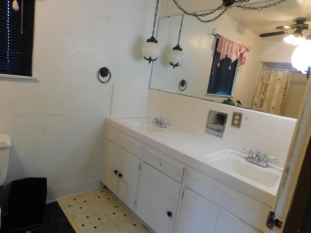full bath featuring a ceiling fan, a sink, and tasteful backsplash