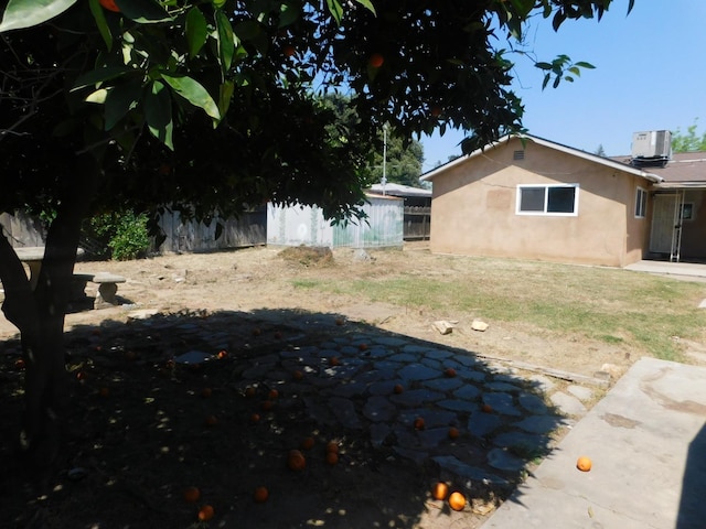 view of yard featuring central AC unit, fence, and a patio