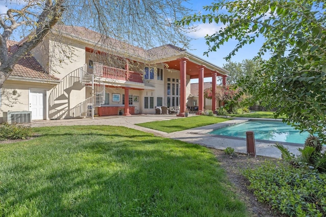 rear view of house featuring central AC, a patio area, stairway, a yard, and stucco siding