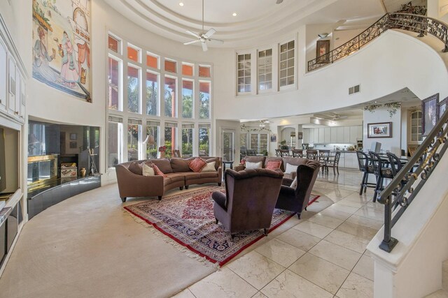 living room featuring a ceiling fan, a towering ceiling, and visible vents