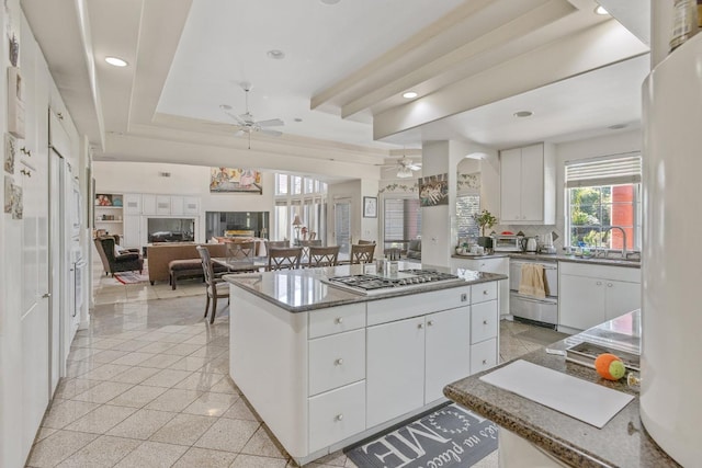 kitchen with dishwasher, a center island, stainless steel gas cooktop, tasteful backsplash, and ceiling fan